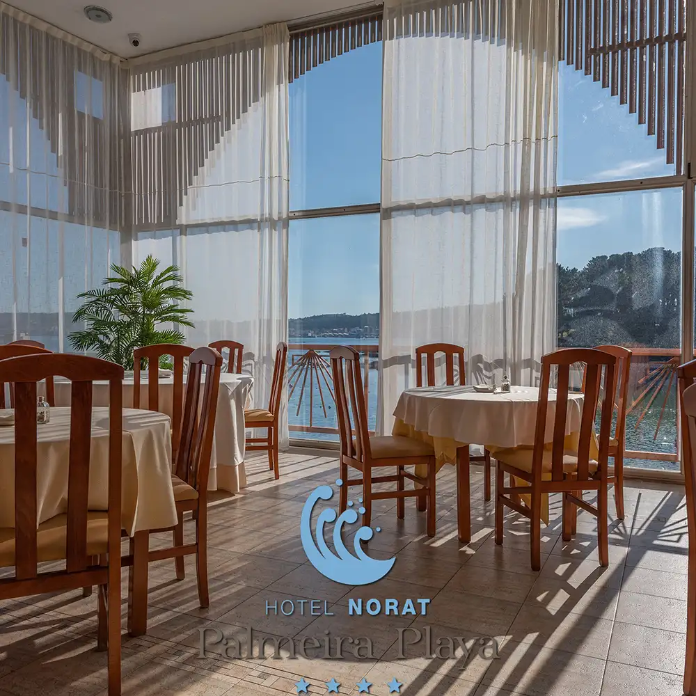 Terraza de hotel con mesas, sillas y cortinas frente al lago, luz del sol.