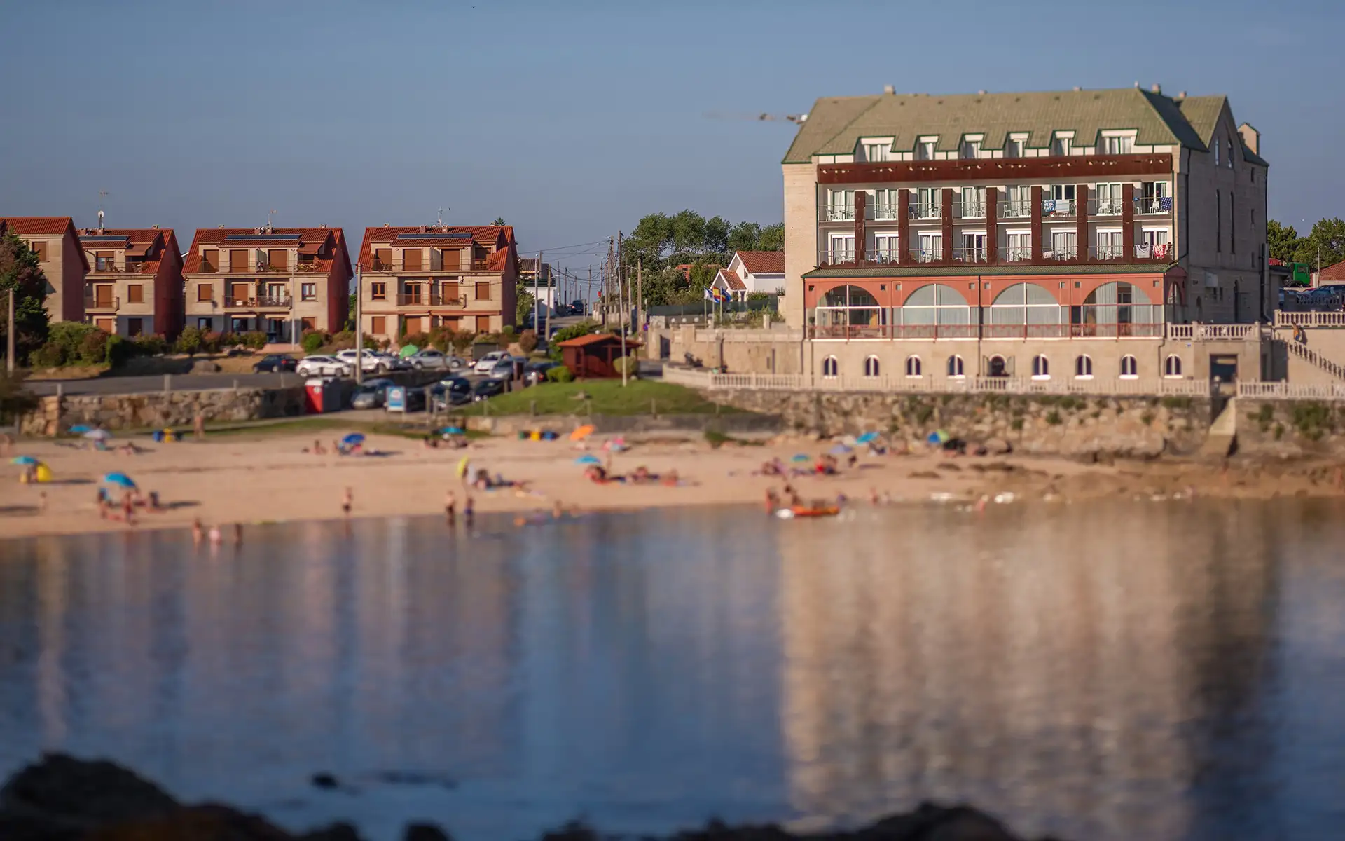 Edificio junto a la playa con barandillas y bungalows en la orilla