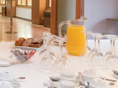 Mesa de desayuno con jarras de jugo y bandejas de comida.