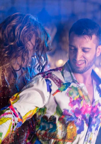 Man and woman dancing at night with colorful, sparkling light effects