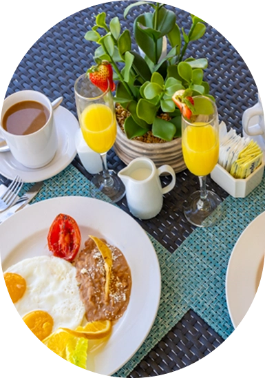 Breakfast table with eggs, coffee, orange juice, and fresh herbs on wicker.