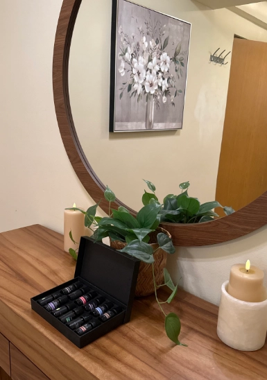 Wooden shelf with candle and plant, floral wall art in indoor corner, 80 chars max