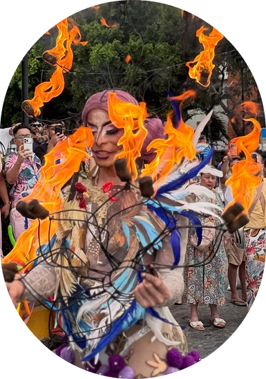 Crowd at a festival with a performer surrounded by floating orange flames