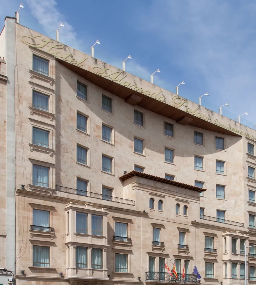 Fachada de edificio de estilo cl&aacute;sico con banderas y letras en el techo