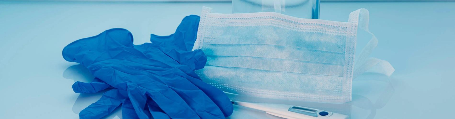 Mascarilla quir&uacute;rgica y guantes de protecci&oacute;n desechables sobre una bandeja