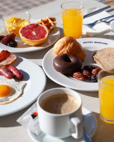 Desayuno con caf&eacute;, jugo y frutas; hotel con variedad de alimentos.