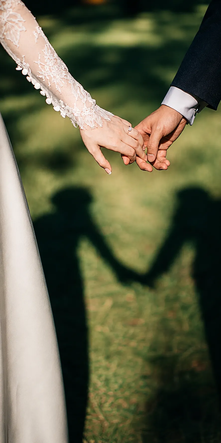 Pareja tom&aacute;ndose de la mano durante una boda al aire libre