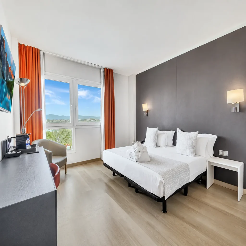 Dormitorio moderno con cama doble, cortinas naranjas y ventanas panor&aacute;micas