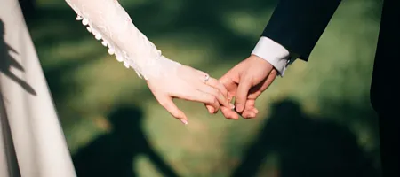 Manos entrelazadas de una pareja durante una ceremonia al aire libre