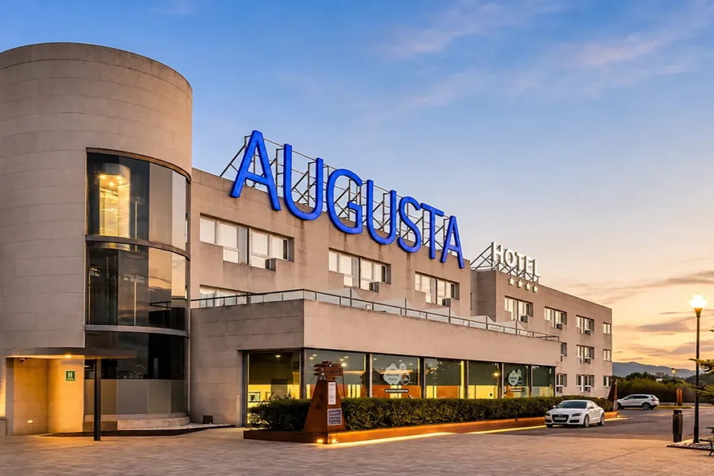 Hotel Ayucushta, edificio moderno con letrero azul y fachada al atardecer