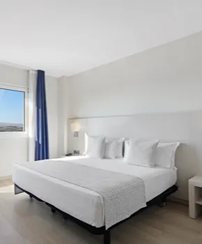 Dormitorio moderno con cama blanca y cortinas azules