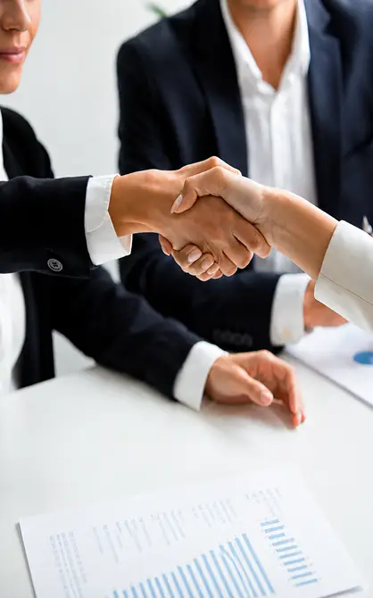 Personas estrechando manos en una reuni&oacute;n de negocios