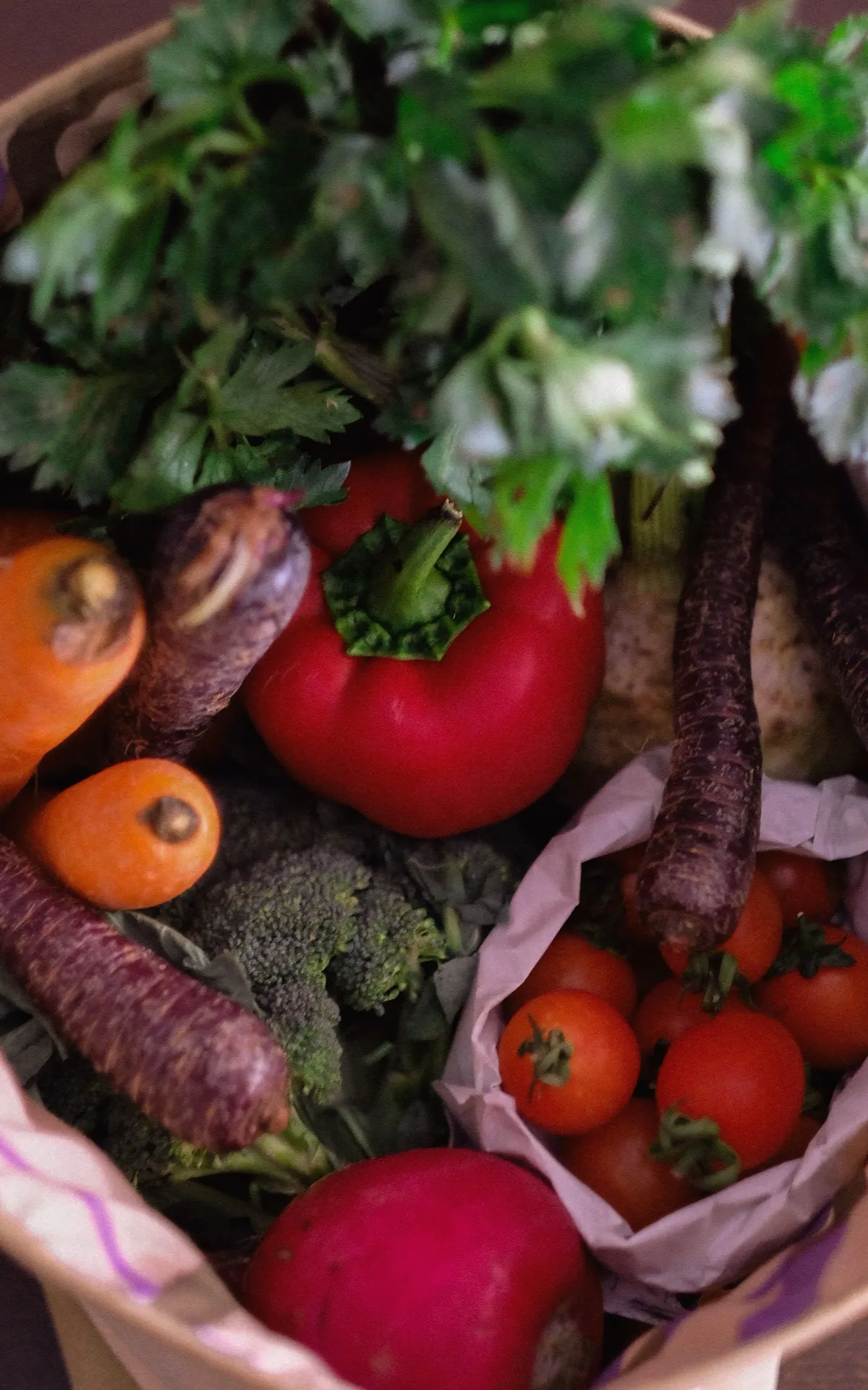 Tomate rojo y verduras frescas en un canasto.