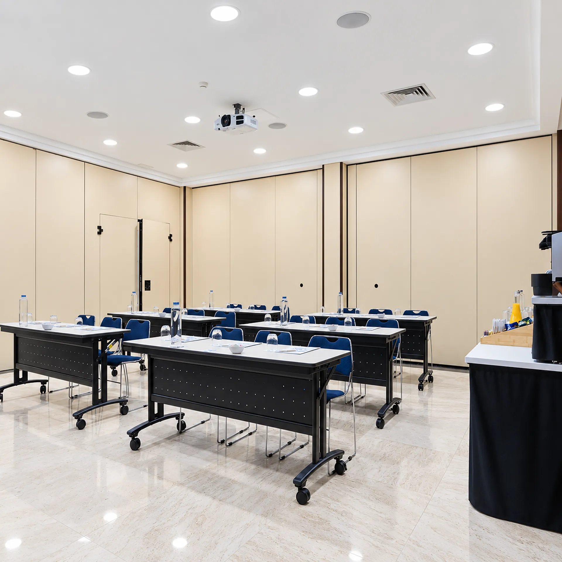 Sal&oacute;n de laboratorio con mesas, sillas azules e iluminaci&oacute;n en el techo
