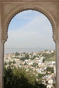 Paisaje urbano visto a través de un arco de piedra.