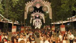 Arco de luces ornamentales y multitud paseando en una feria nocturna
