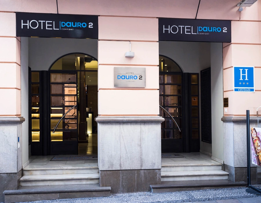 Entrada del Hotel D'auro 2 con letreros y fachada exterior.