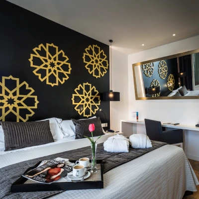 Dormitorio moderno con cama doble y decoraci&oacute;n de copos dorados en la pared