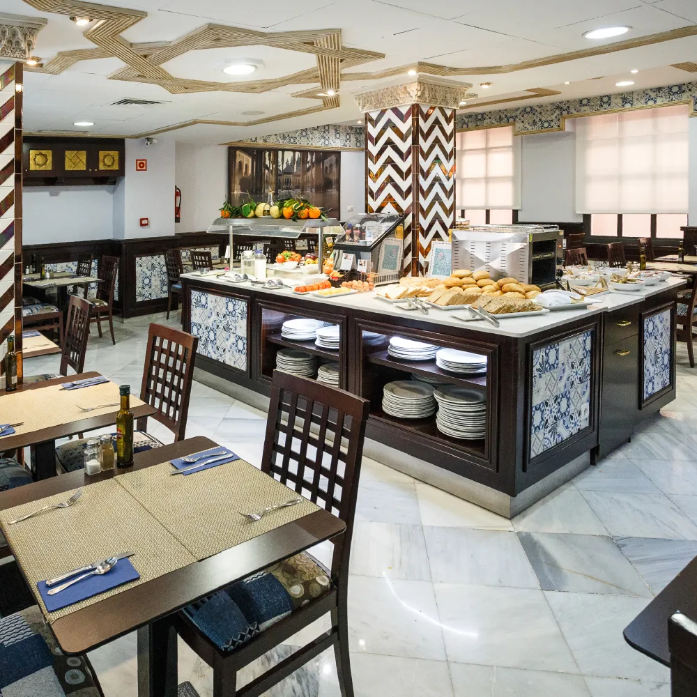 Buffet de petit-d&eacute;jeuner dans la salle &agrave; manger de l'h&ocirc;tel avec des tables et des assiettes, d&eacute;coration arabe
