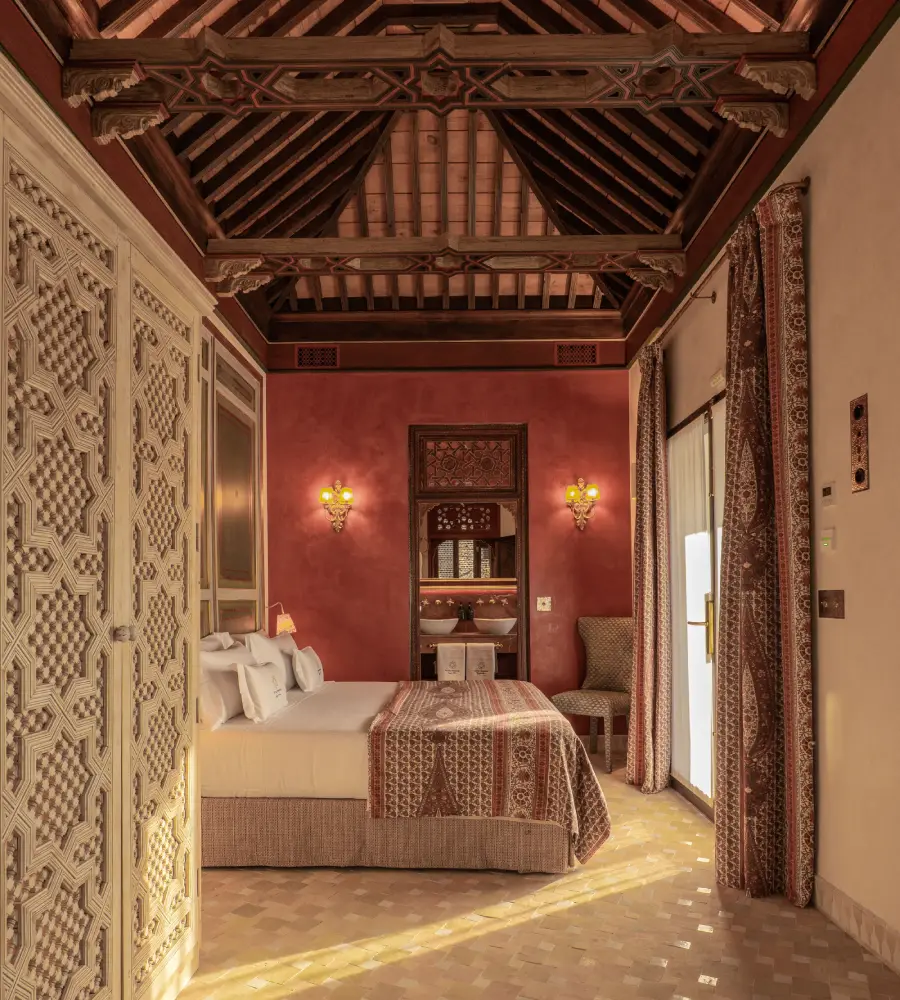 Habitaci&oacute;n de lujo con cama, cortinas y techo de madera tallada, estilo cl&aacute;sico