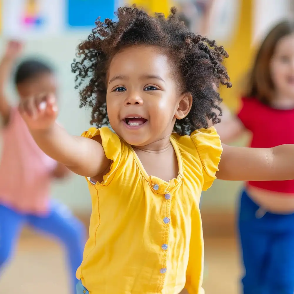 Ni&ntilde;a afro sonriente con blusa amarilla en un aula infantil