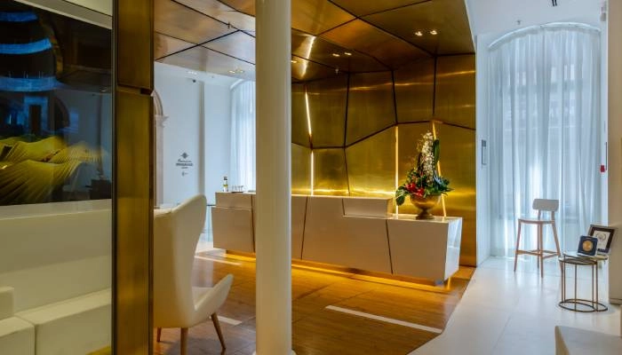 Sala moderna com recep&ccedil;&atilde;o, mesa com flores e ilumina&ccedil;&atilde;o quente, ao lado de janelas