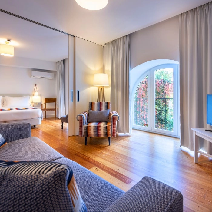 Modern room with armchairs, curtains, and window overlooking the garden