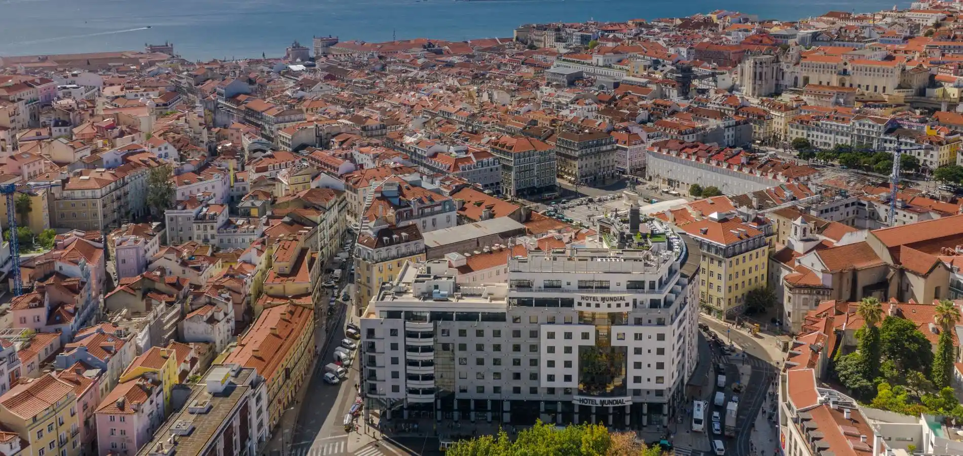 Vista a&eacute;rea de pr&eacute;dios e telhados em Lisboa, com o Hotel Mundial em destaque