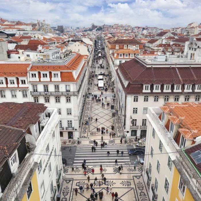Vista a&eacute;rea de calle central con azulejos, tejados rojos y multitud en Lisboa