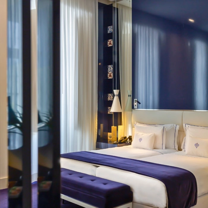 Modern room with king bed and light curtains in shades of blue and white