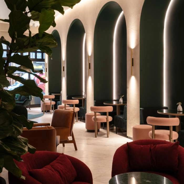 Interior of modern lounge with red sofas and illuminated arches.