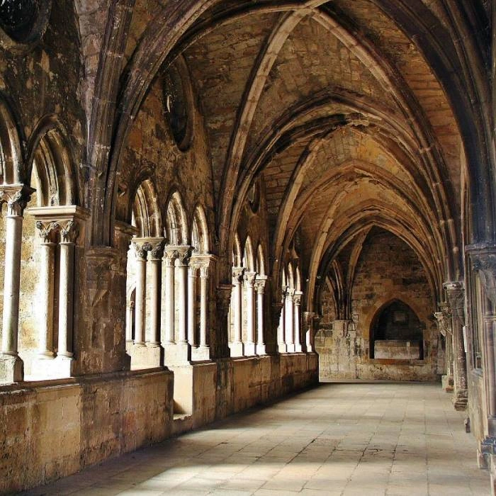 Interior de iglesia rom&aacute;nica con columnas y arcos de piedra y piso de losas