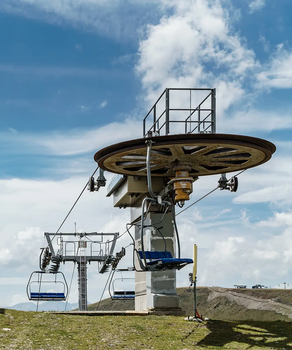 Telef&eacute;rico y cabina junto a estaci&oacute;n con rueda giratoria, cielo con nubes