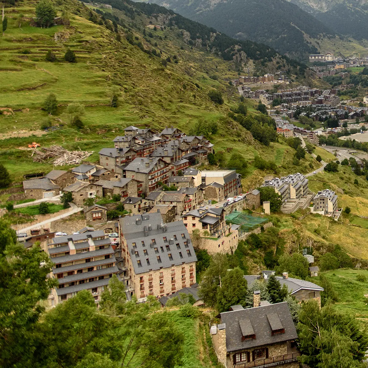 Vista de un pueblo monta&ntilde;oso con valle verde y edificios en ladera