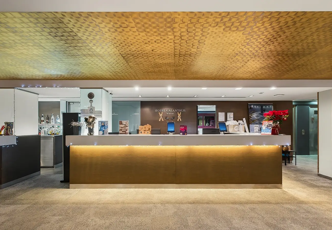 Recepci&oacute;n de hotel con mostrador iluminado y letrero &ldquo;Hotel Galanthus&rdquo;