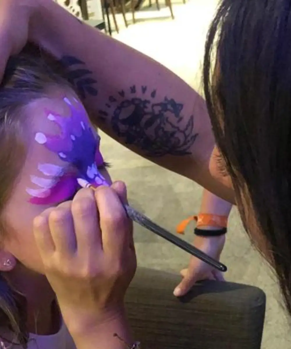 Persona tatuando un brazo con una m&aacute;quina rotativa, en primer plano.