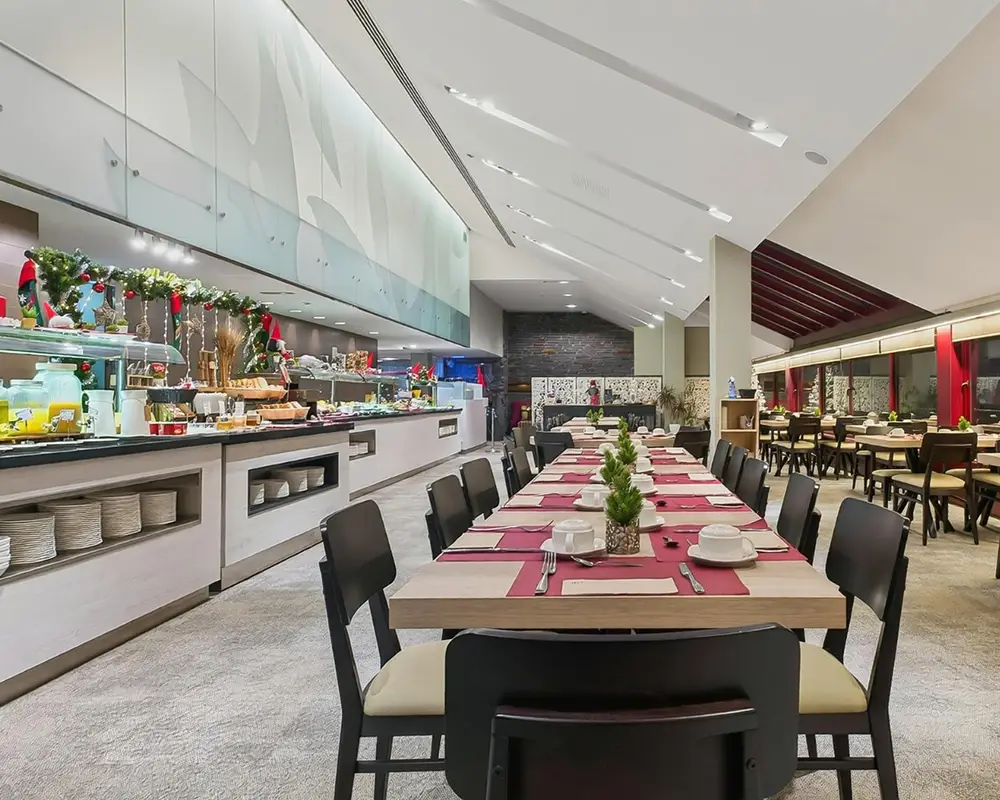 Buffet navide&ntilde;o y mesas con manteles rojos en un sal&oacute;n de hotel moderno