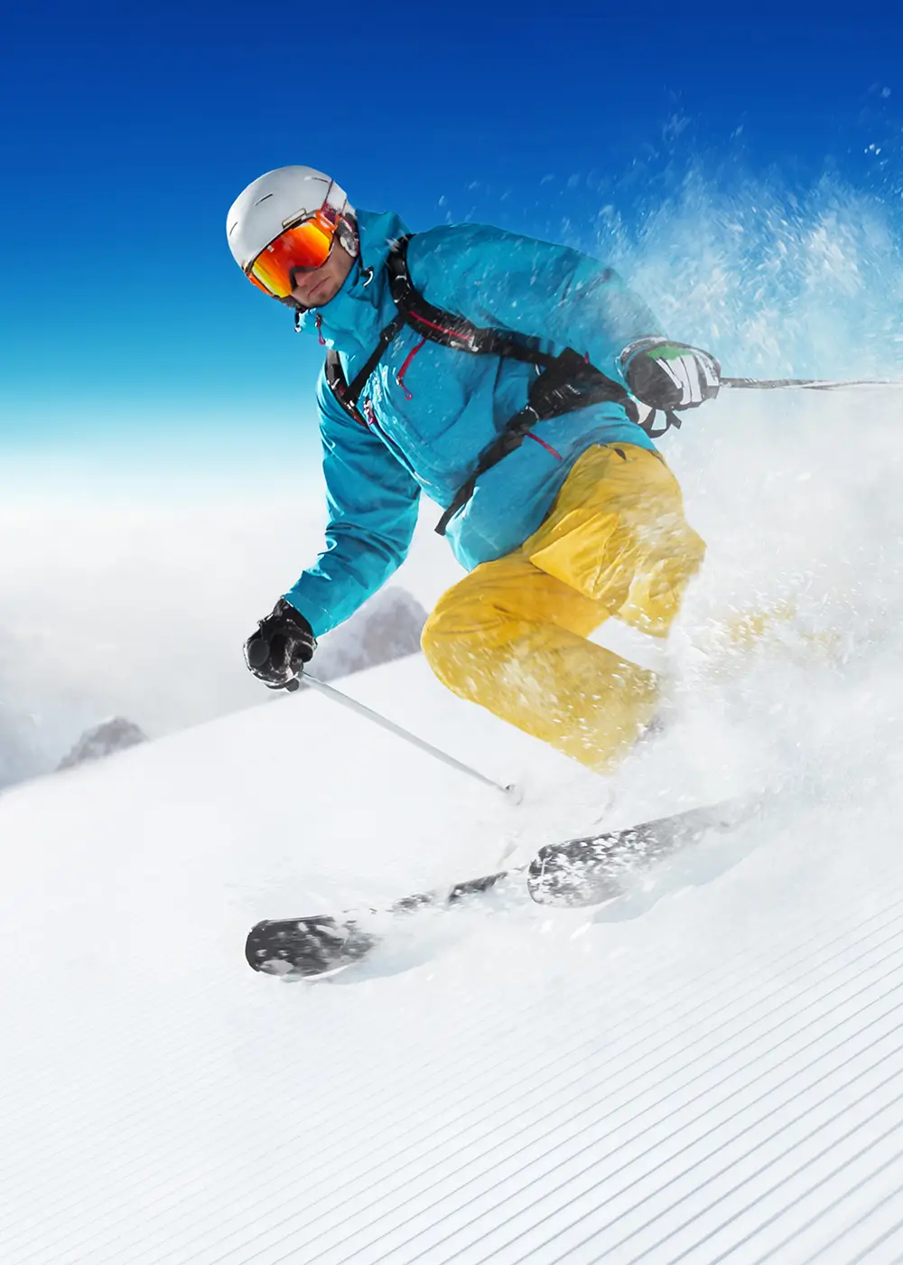 Esquiador con casco y gafas, salpicando nieve mientras baja por la pista
