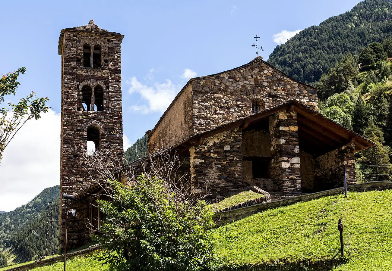 Antigua iglesia de piedra con campanario, en un valle entre monta&ntilde;as