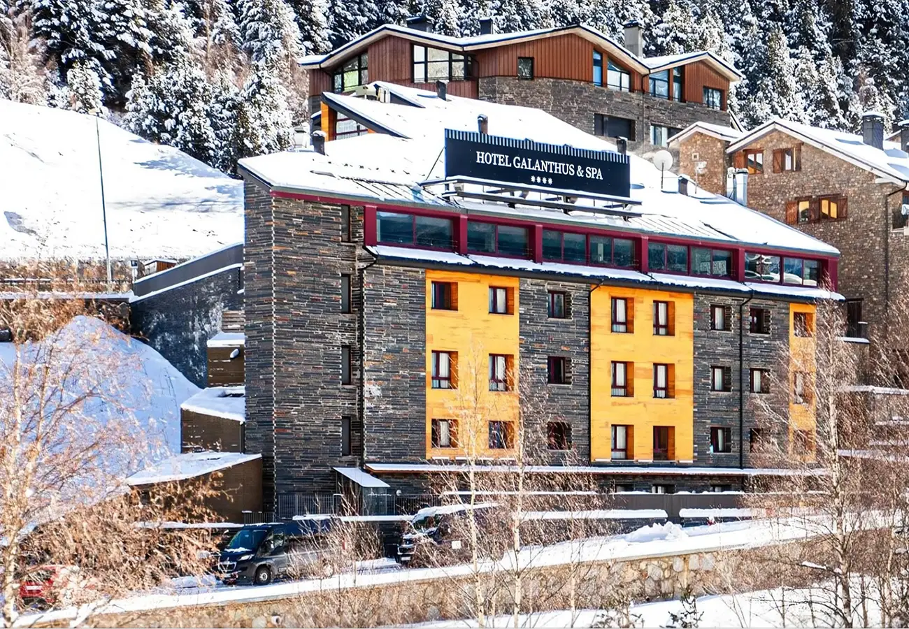Hotel Galanthus & Spa en monta&ntilde;a nevada, con edificio de piedra y techos blancos
