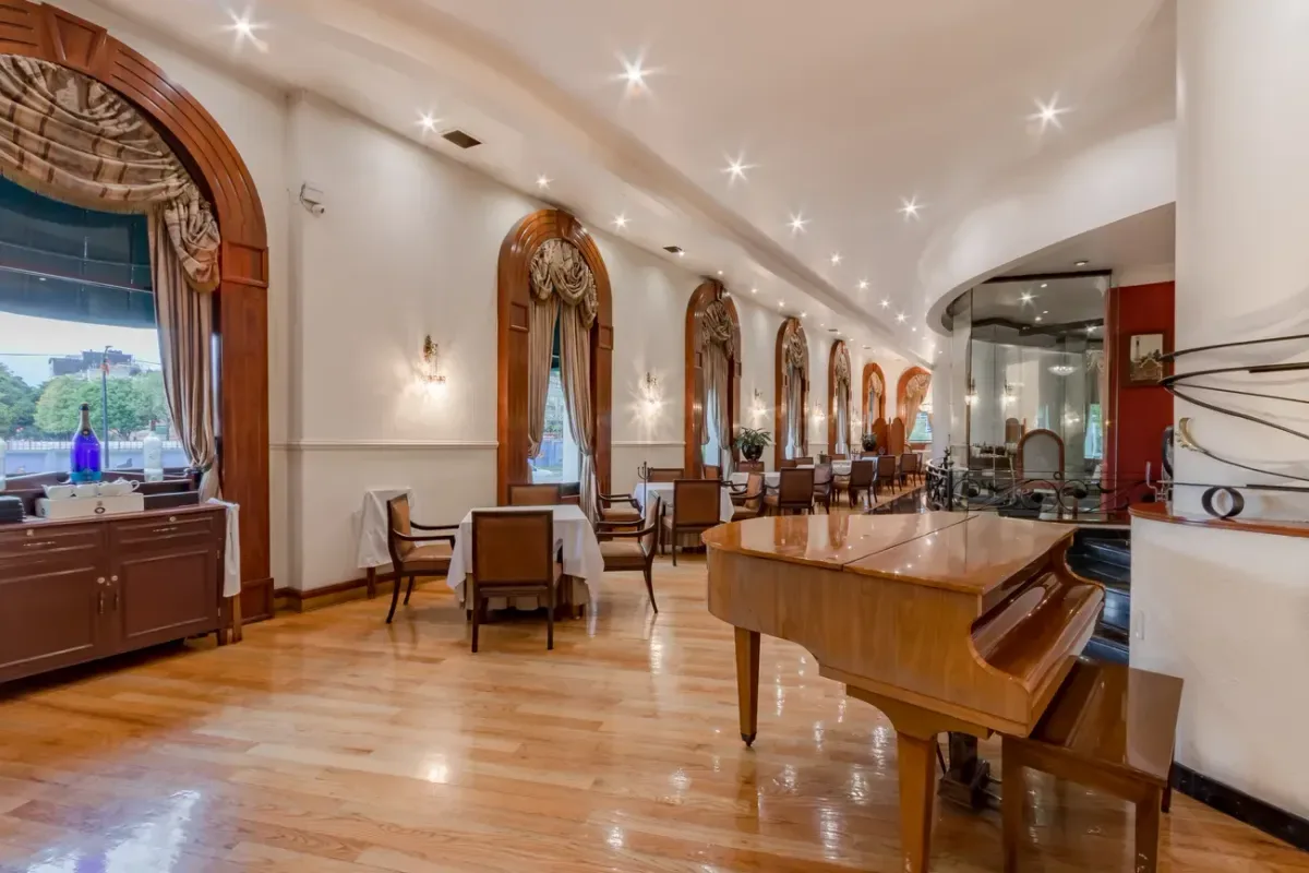 Comedor elegante con mesa, sillas de madera y mesa de m&aacute;rmol con iluminaci&oacute;n LED.