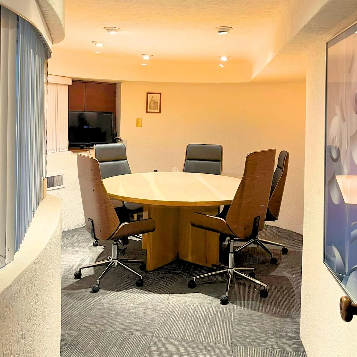 Sala de juntas con mesa rectangular y sillas de oficina.