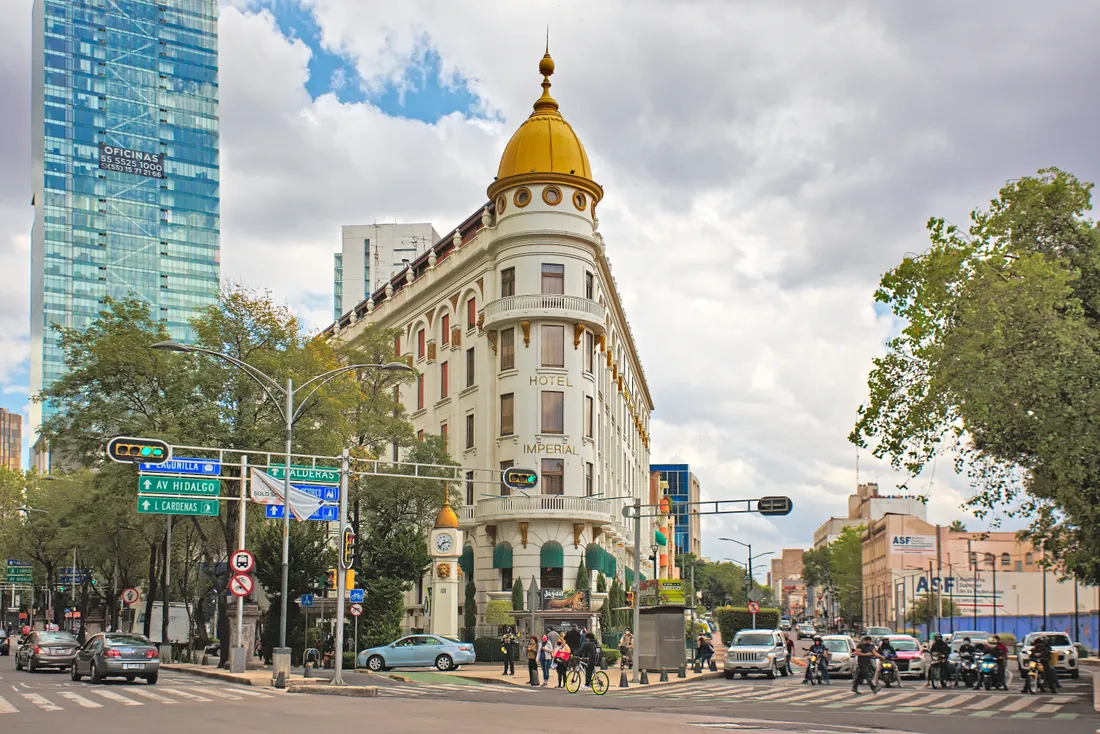 Hotel Imperial con c&uacute;pula dorada en avenida urbana, con autos y motos