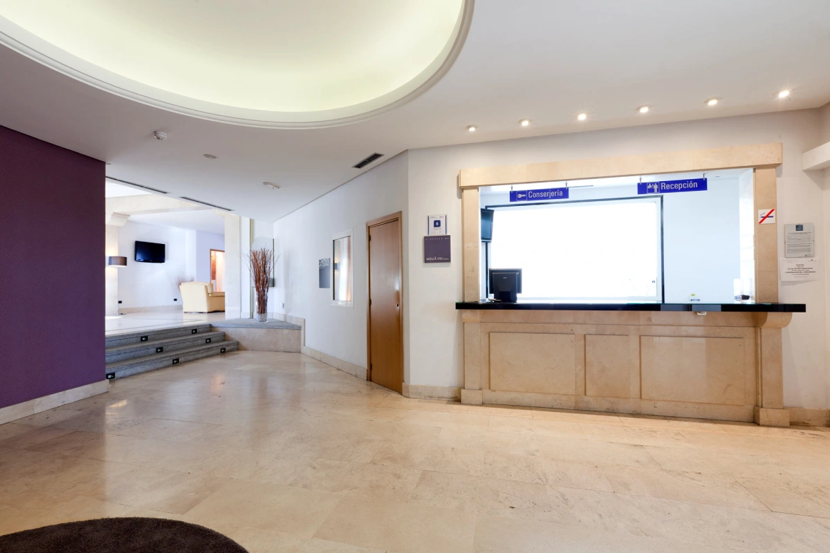 Hotel reception with marble counter and door in the back