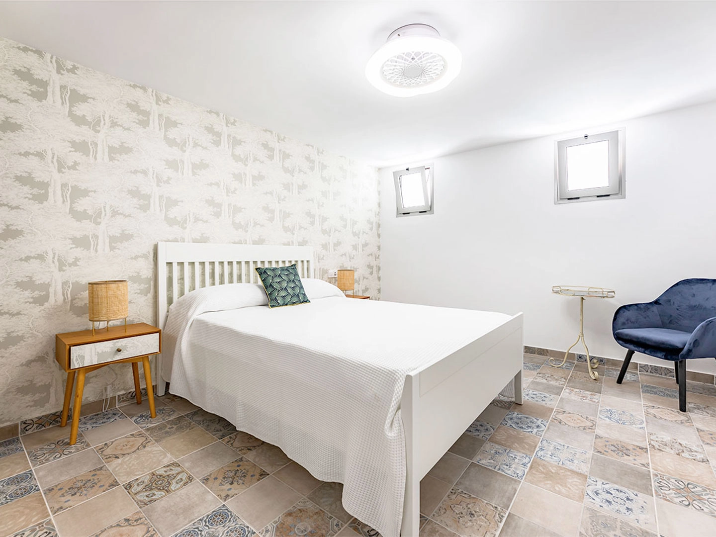 Dormitorio con cama blanca y decorado en tonos claros.