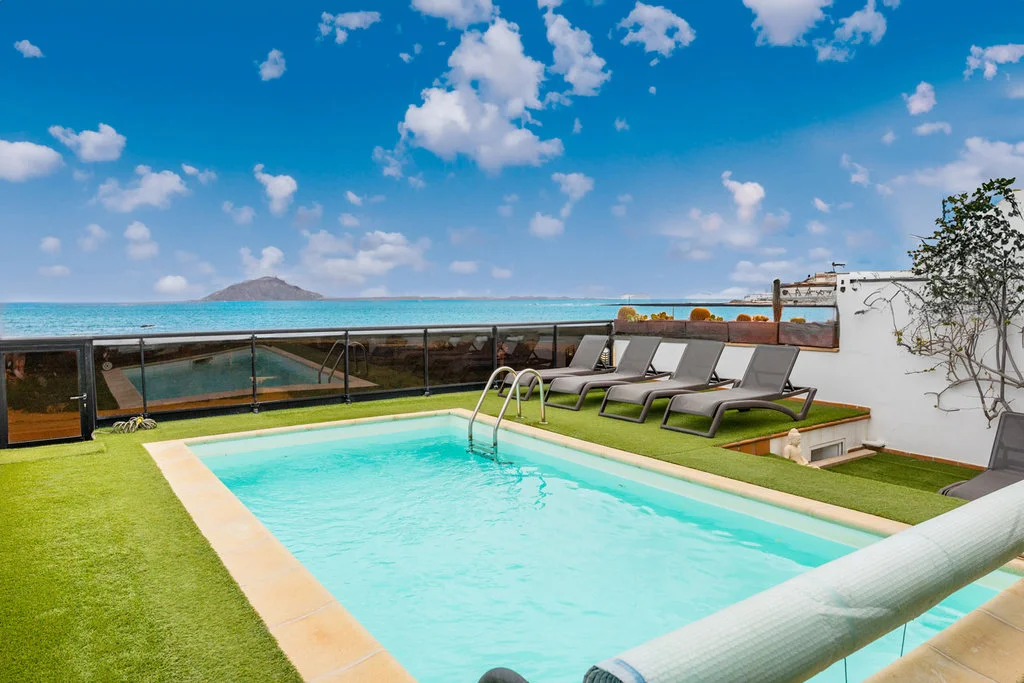 Piscina privada con vistas al mar e Isla de Lobos en villa en Corralejo.