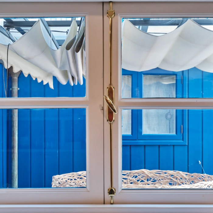 Puertas con cortinas y ventanas; interior con azul y cuerda decorativa