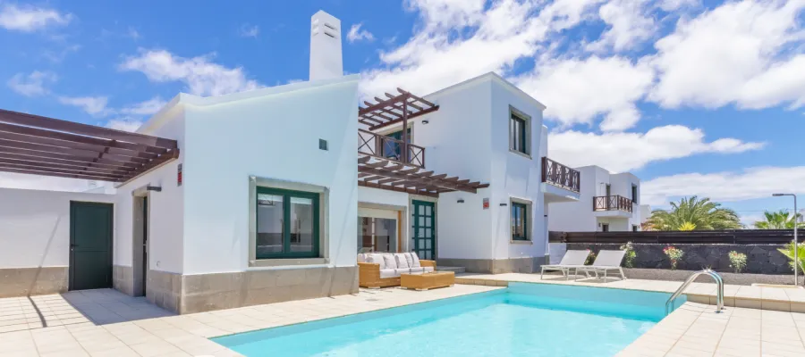 Casa moderna con piscina y cielo azul.