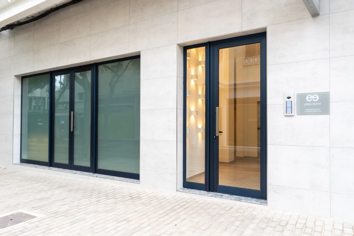 Entrada de un edificio moderno con puertas y ventanas de cristal.