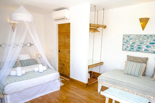 Habitación con cama de matrimonio y mosquitera de techo en hotel Wawa Tarifa Affiliated by Senator (Tarifa, Cádiz)